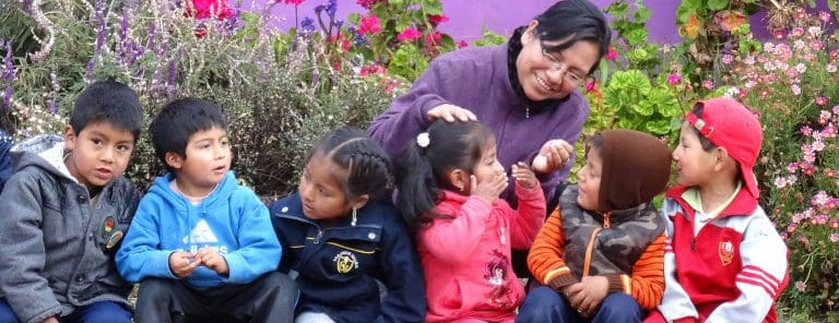 A teacher with the children in the garden at Picaflor House
