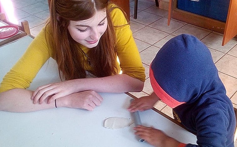 A student working with a child at Picaflor House