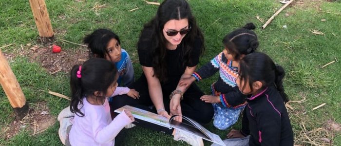 Volunteer reading to children at Picaflor House, Cusco