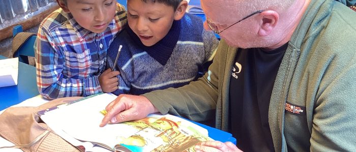 Volunteer reading with children on the mobile library in Peru