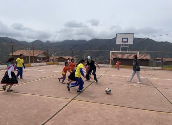 Larissa playing football with the children"