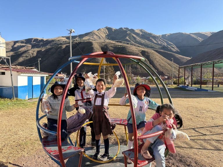 Children playing on a climbing frame at Picaflor House with the Andes behind