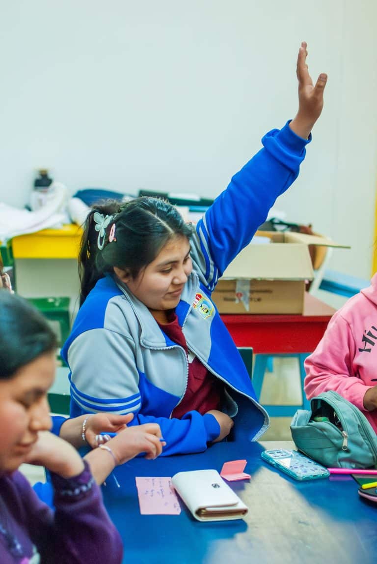 Schoolgirl raising her hand during a class in Cusco