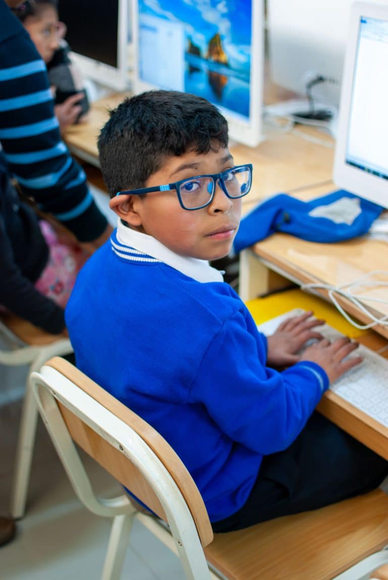 Boy in glasses working at a computer class