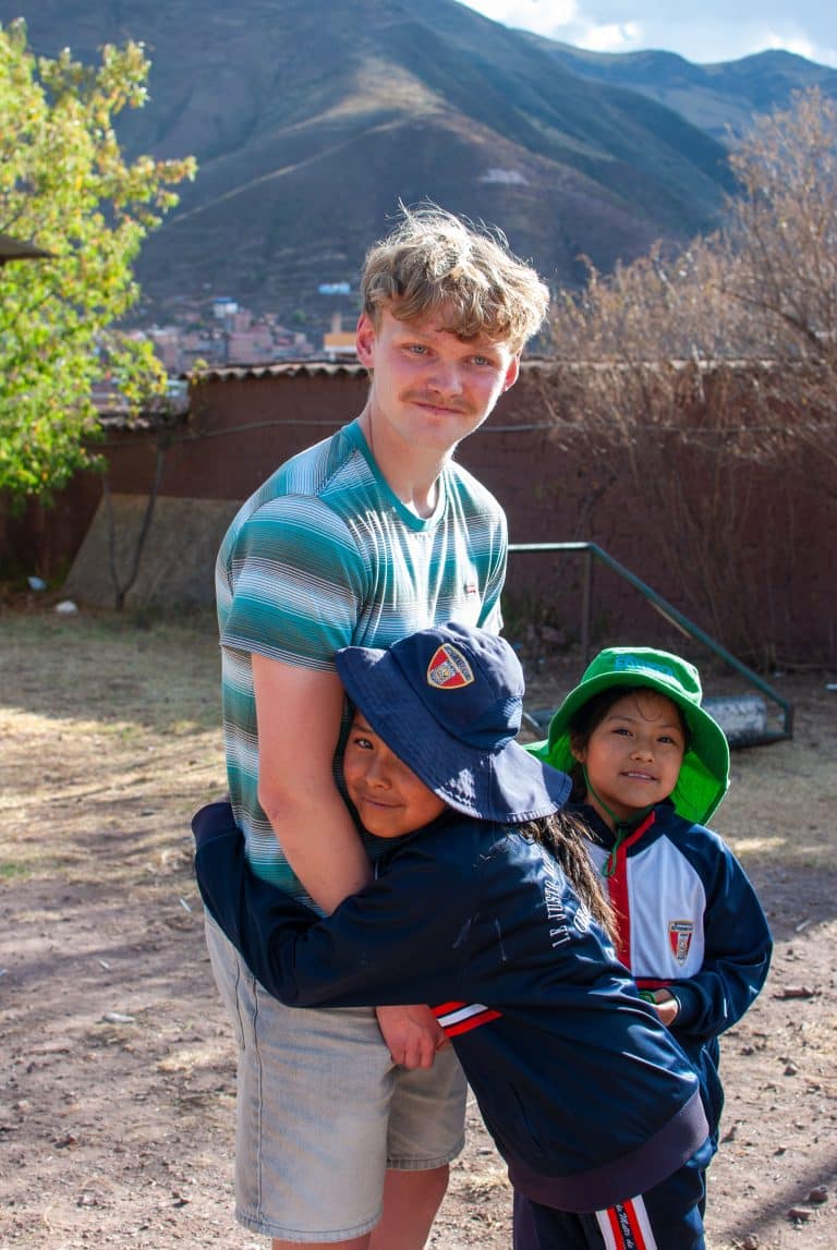 Volunteer hugging two children at Picaflor House