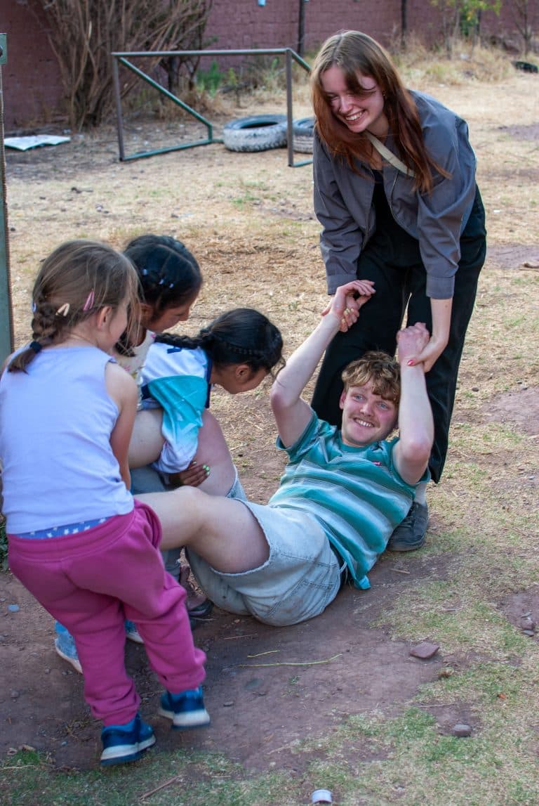 Volunteers playing with children at Picaflor House