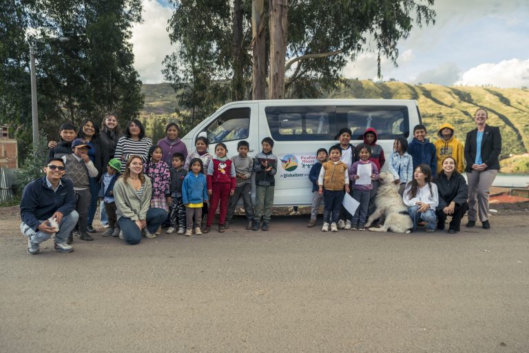 Mobile library team and children beside the library van near Cusco