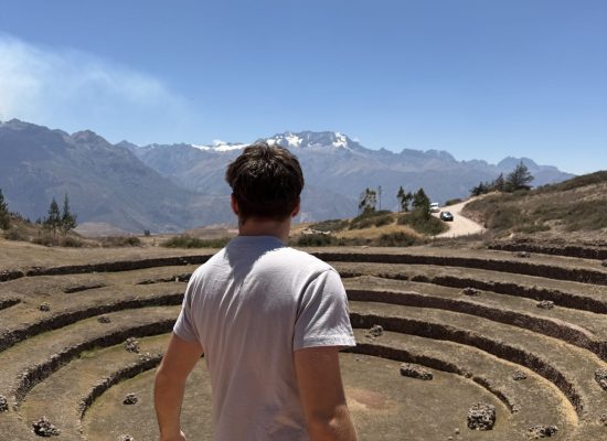 Volunteer looking over the circular Inca terraces of Moray in the Sacred Valley"