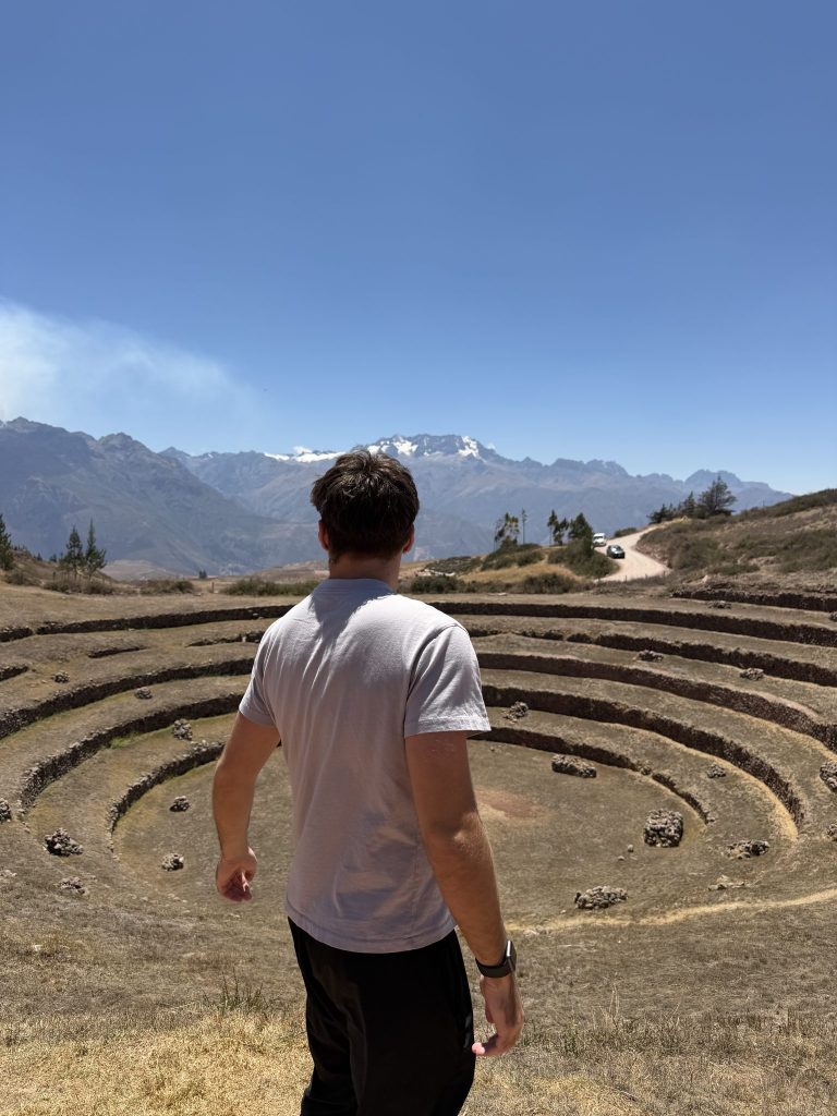 Volunteer looking over the circular Inca terraces of Moray in the Sacred Valley